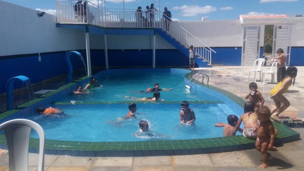 Várias crianças brincando dentro de piscina